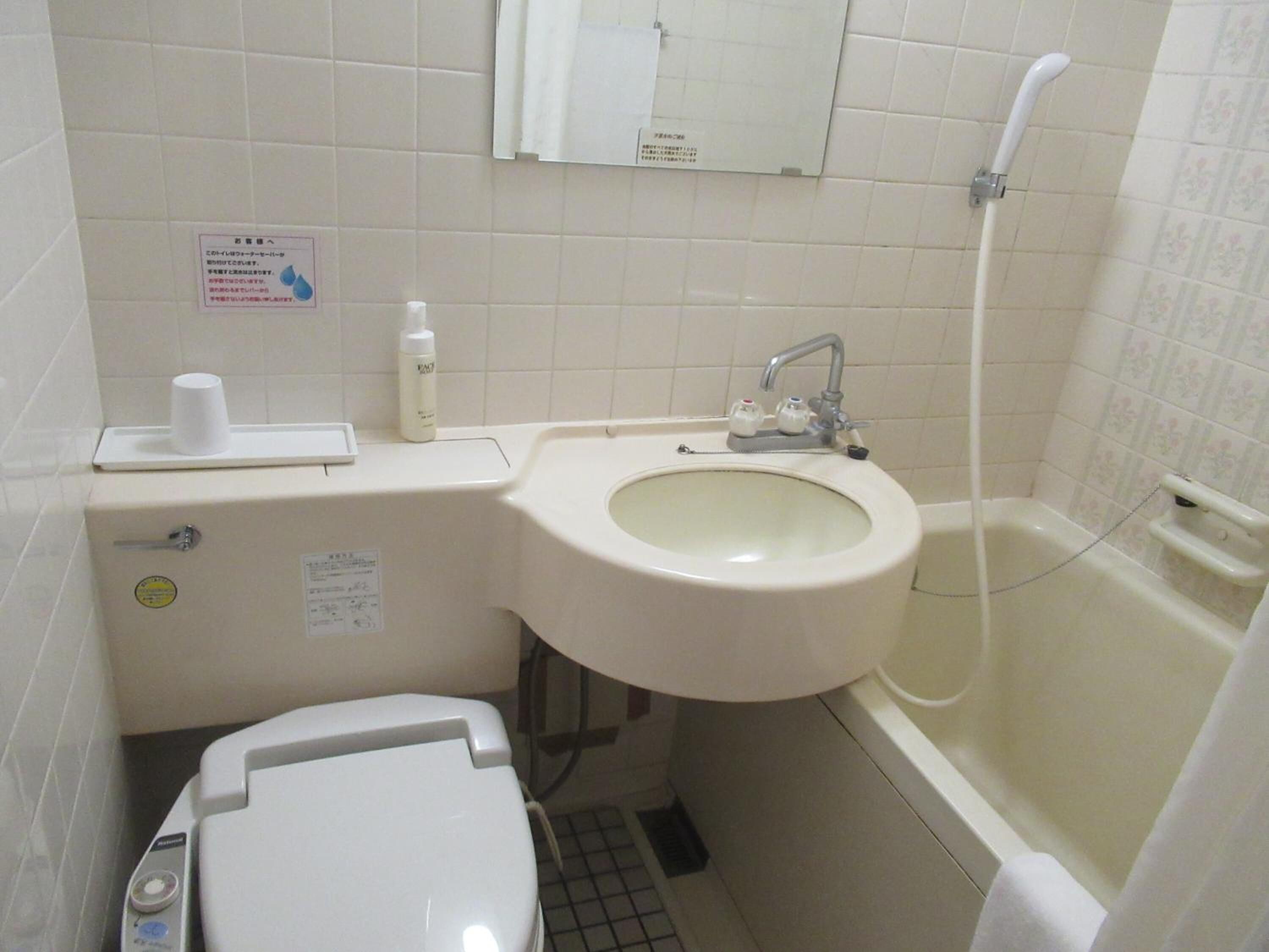 A bathroom with a toilet, sink, and bathtub.