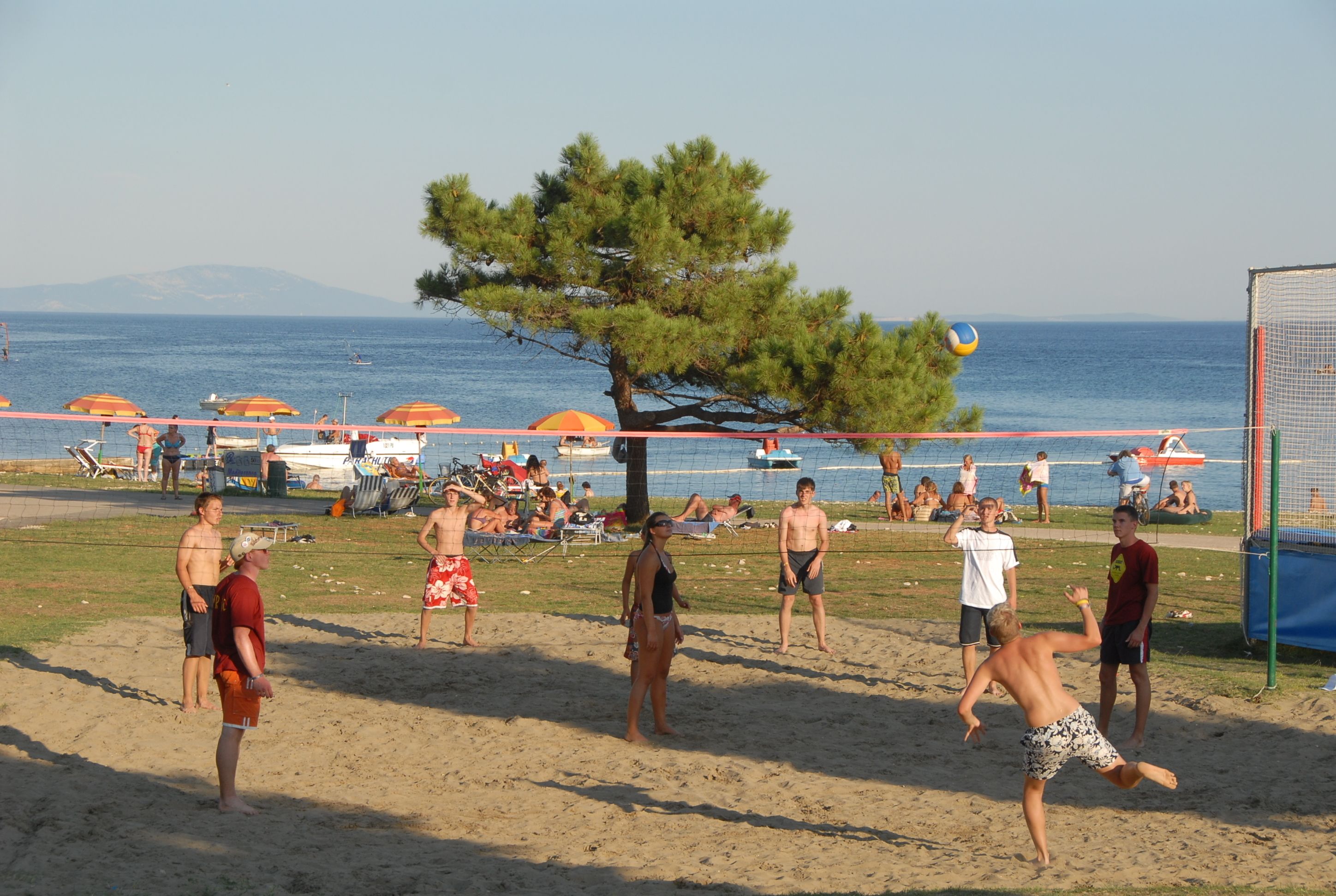 Un match de volleyball de plage avec des joueurs et des spectateurs.