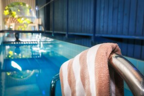 Una piscina con una toalla sobre una silla de metal.