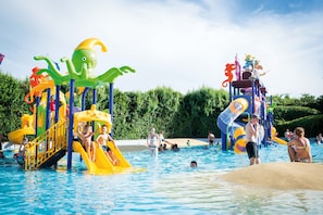 Een waterpark met kleurrijke speeltoestellen en een zwembad.