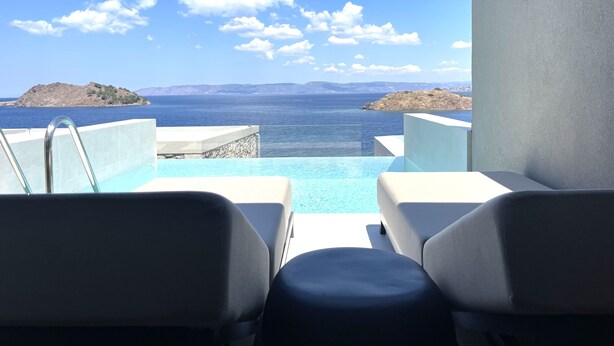 A poolside area with a view of the sea and distant islands. - Eleia Seafront Rooms & Villas (Lesvos)