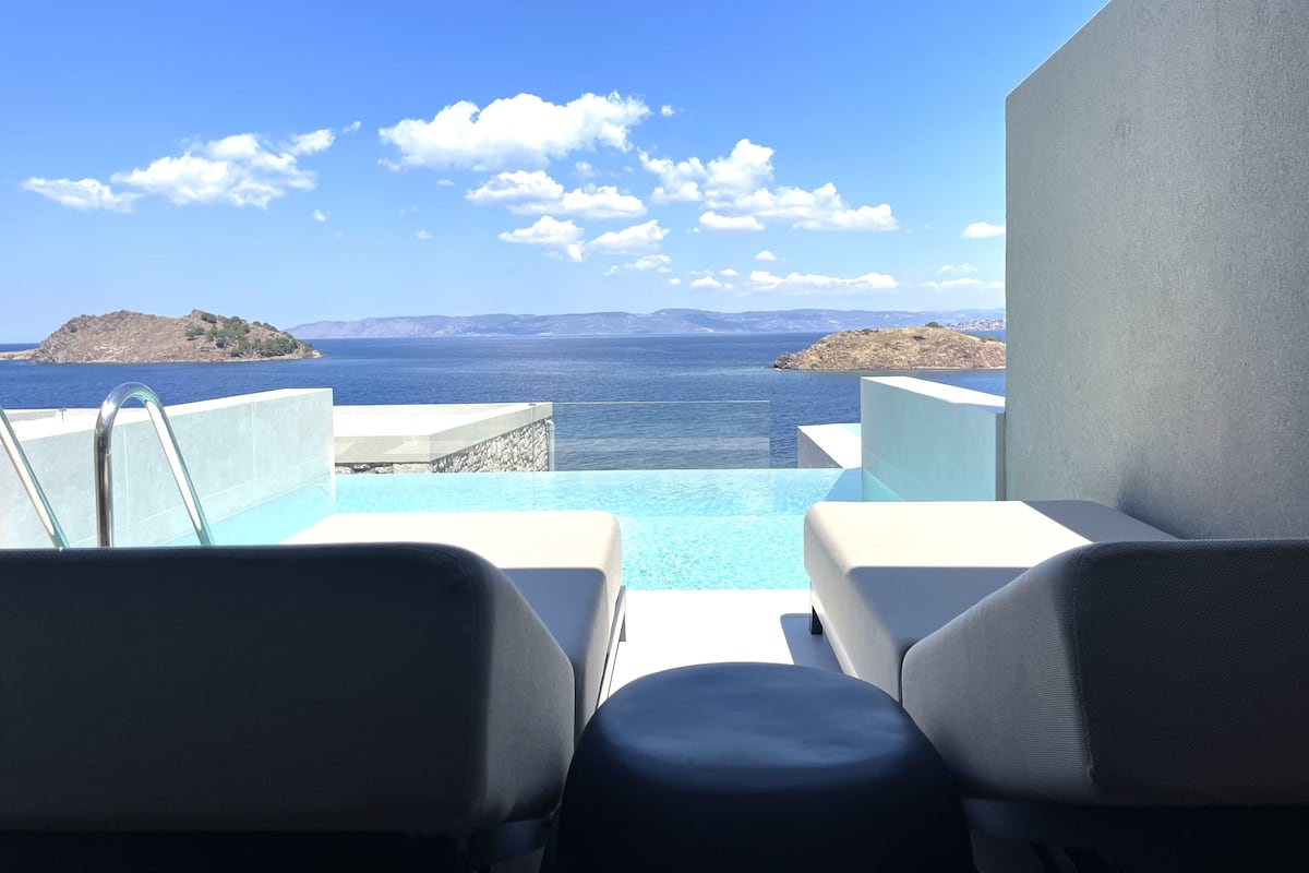 A poolside area with a view of the sea and distant islands.