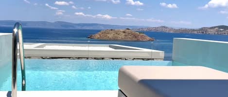 Una piscina con vistas al mar y una pequeña isla.