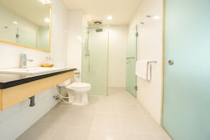 A modern bathroom with a toilet, sink, and shower area. - Alam Permai (Bandung)