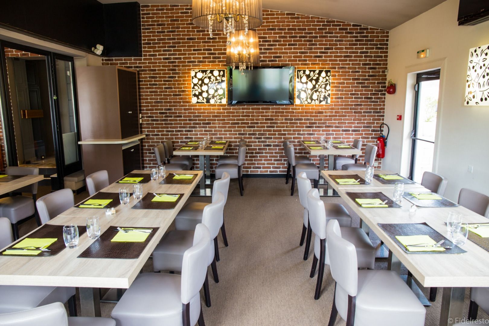 A restaurant with brick walls, multiple tables, and chairs.