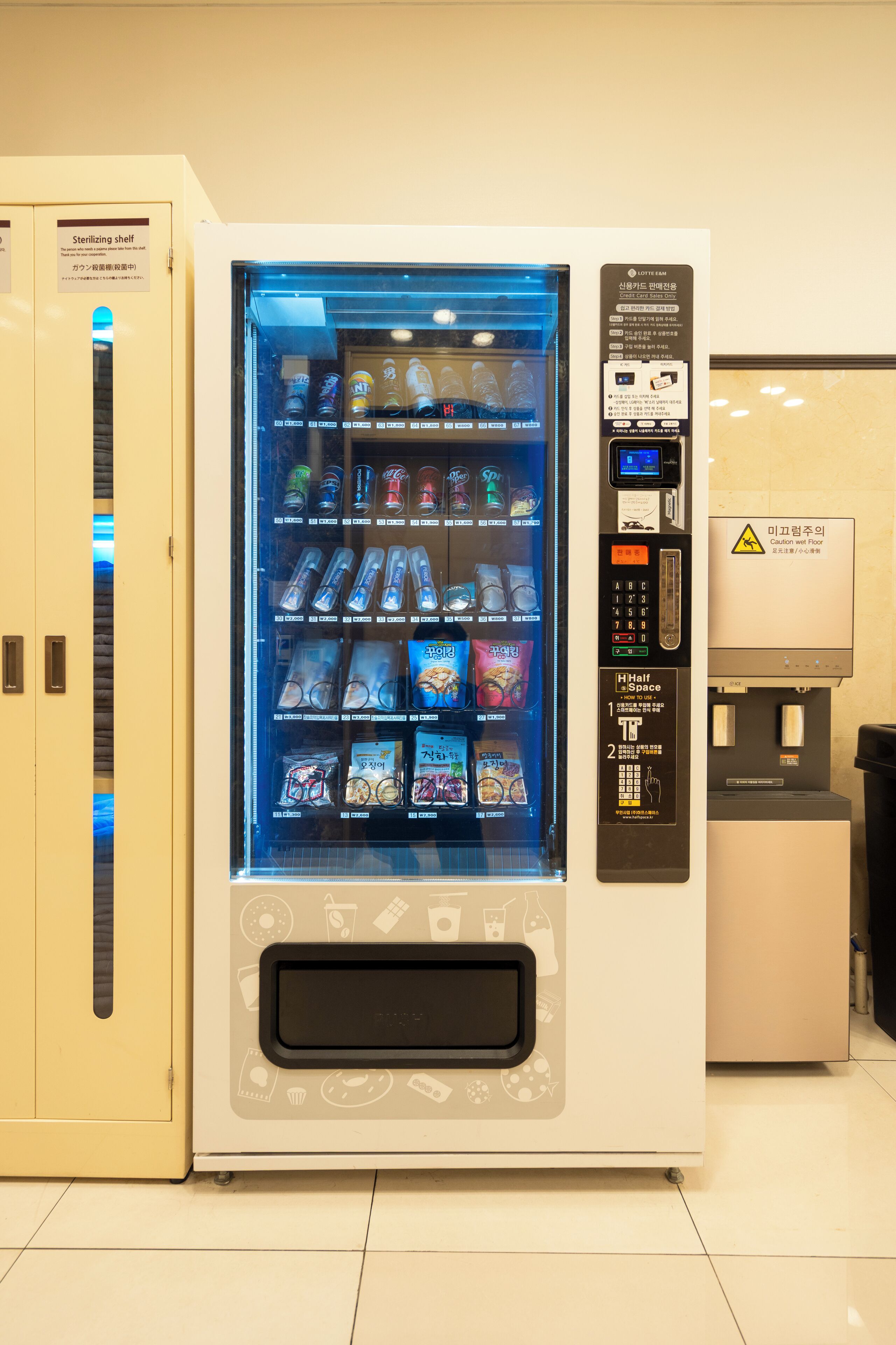 A vending machine with a variety of snacks and drinks, a payment interface, and a sterilizing shelf.
