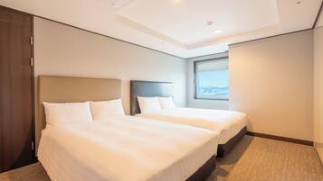 A hotel room with two beds, a large window, and a view of the cityscape.