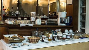 Una barra de desayuno con diversos alimentos, frascos de conservas y una máquina de café.