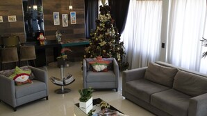 Een moderne woonkamer met een bank, fauteuils, een salontafel en een kerstboom.