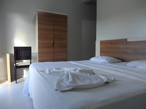 Una habitación de hotel con una cama grande, un armario de madera y una silla de diseño exclusivo.
