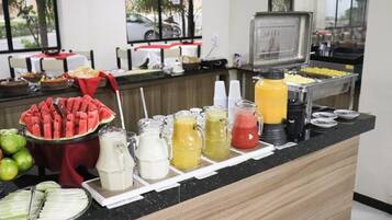 A buffet counter with various food items and beverages.