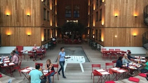 Un comedor interior con mesas y sillas, una zona de servicio central y paredes de madera.