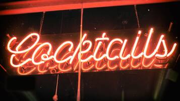 Un letrero de neón con la palabra 'Cocktails' en letras cursivas.