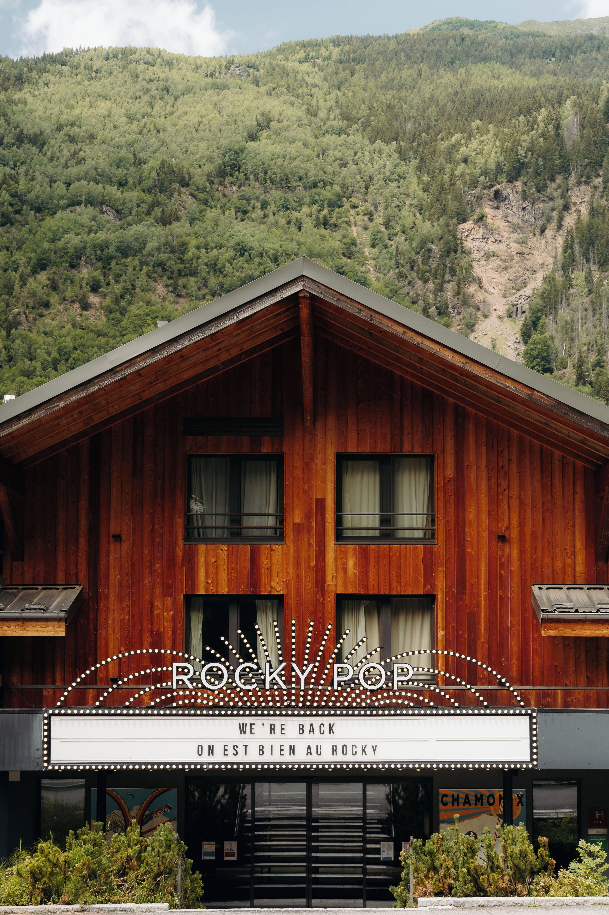 Un edificio de madera con un cartel de marquesina que dice 'ROCKY POP' y 'VOLVIMOS A EST BIEN AU ROCKY'.
