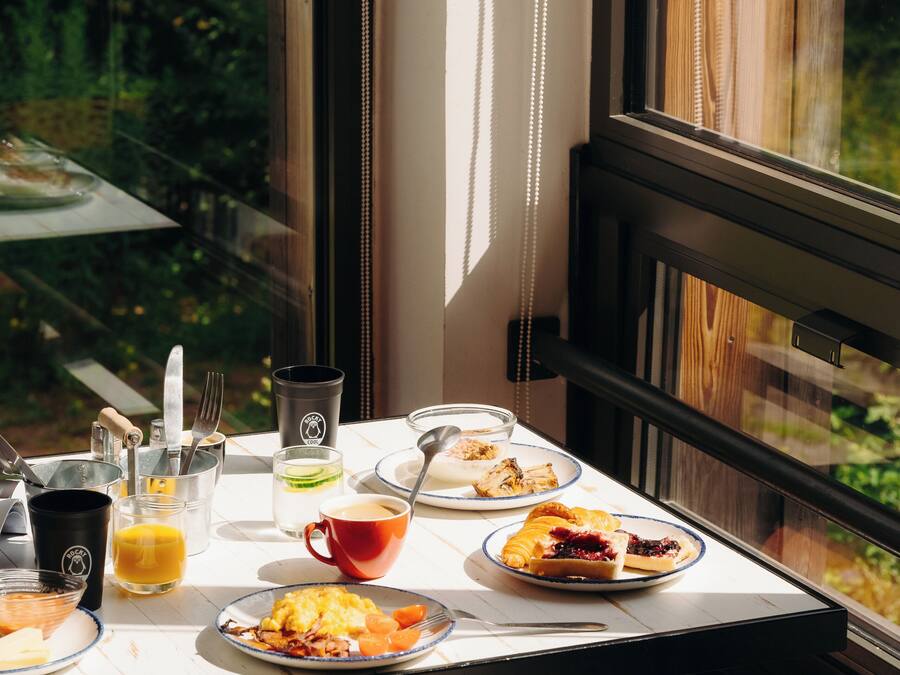 A breakfast table with plates of food, a glass of orange juice, and a coffee cup.