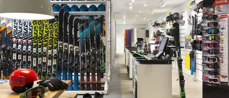 A ski equipment store with shelves of skis, helmets, and goggles.