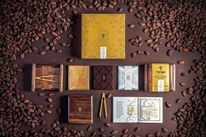 Una selección de cajas de chocolate y granos de cacao dispuestos sobre una superficie.