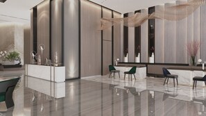 Un lobby moderno con mostrador de recepción, zona de estar y elementos decorativos.