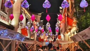A crowded street with traditional lanterns and flags, indicating a festive atmosphere. - Jinjiang (Anqing Dananmen Daopashi Ancient Street) (Anqing)