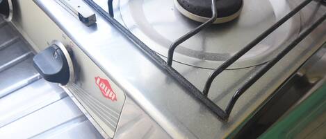 Una estufa a gas con una perilla de control y un quemador.