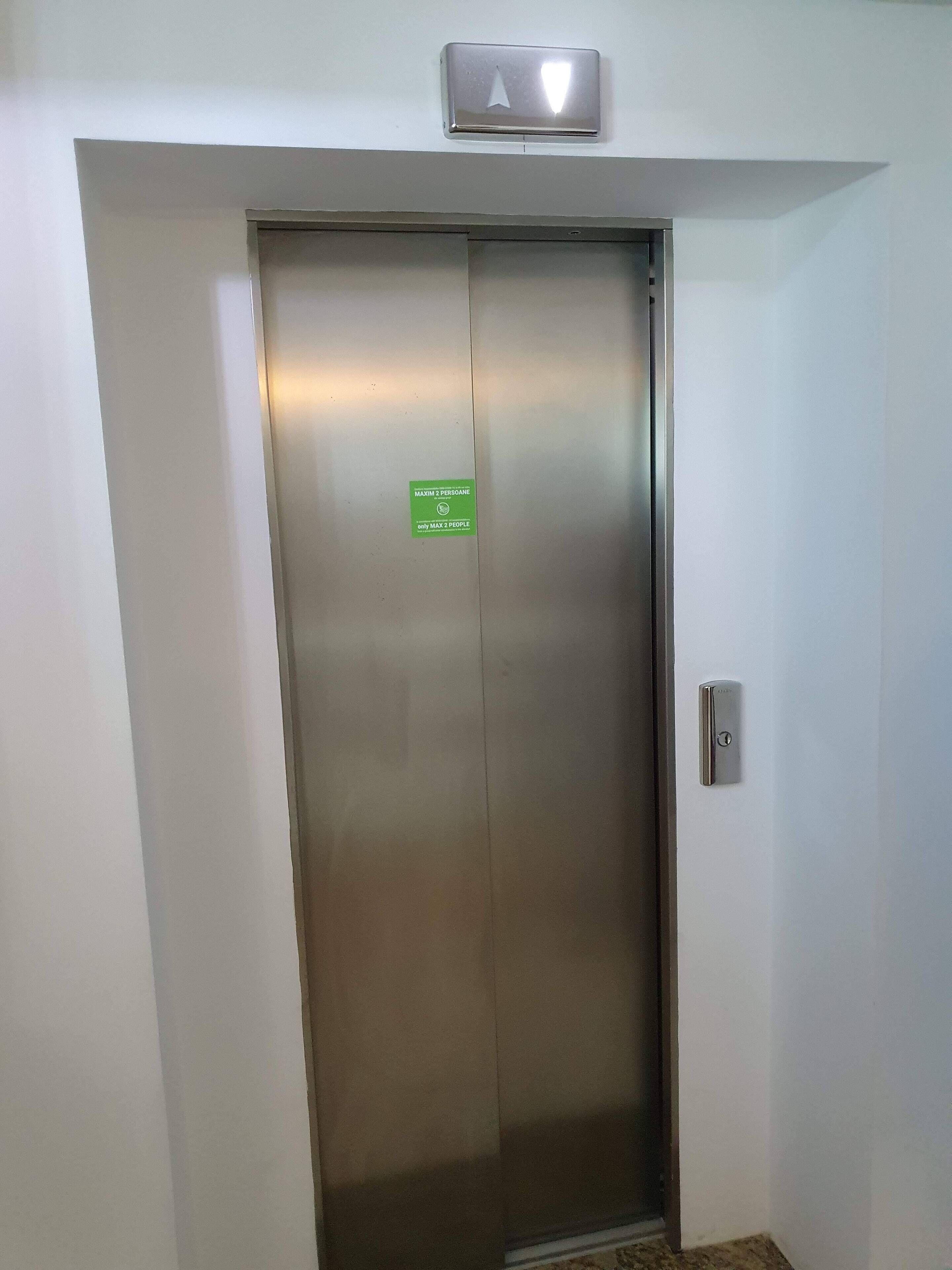 An elevator with a sign indicating a maximum of 2 people.