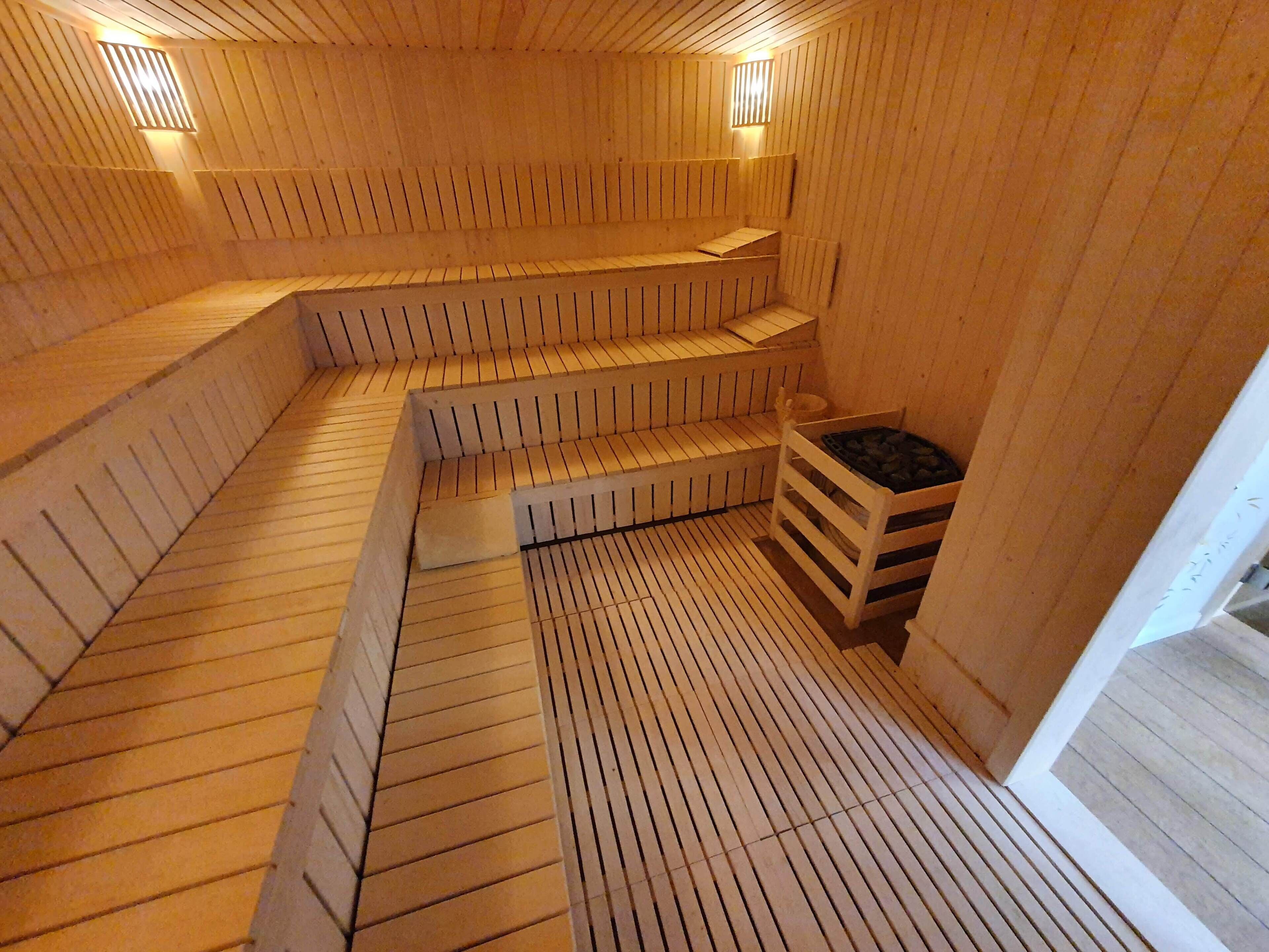 Una sauna amb seients de fusta i una petita zona de descans.