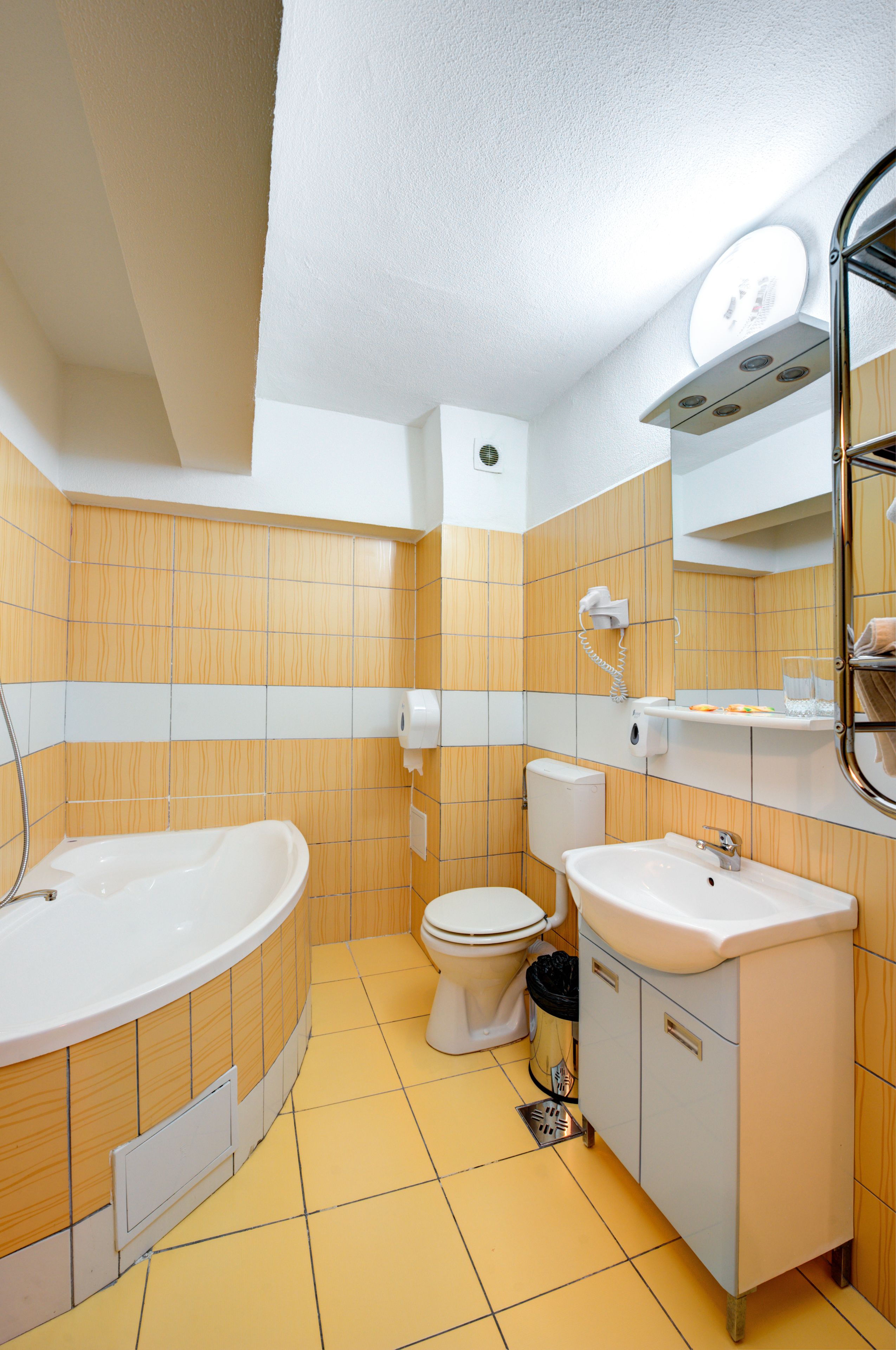 Une salle de bain équipée d’une baignoire, de toilettes, d’un lavabo et d’un miroir.