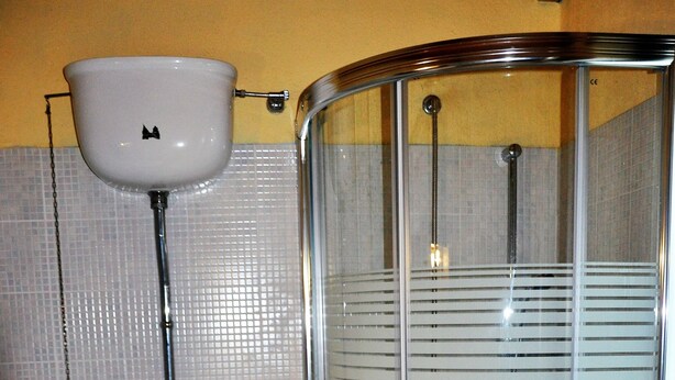 A bathroom with a glass-enclosed shower, a toilet, and a sink. - Borgo Nociquerceto (Tarano)