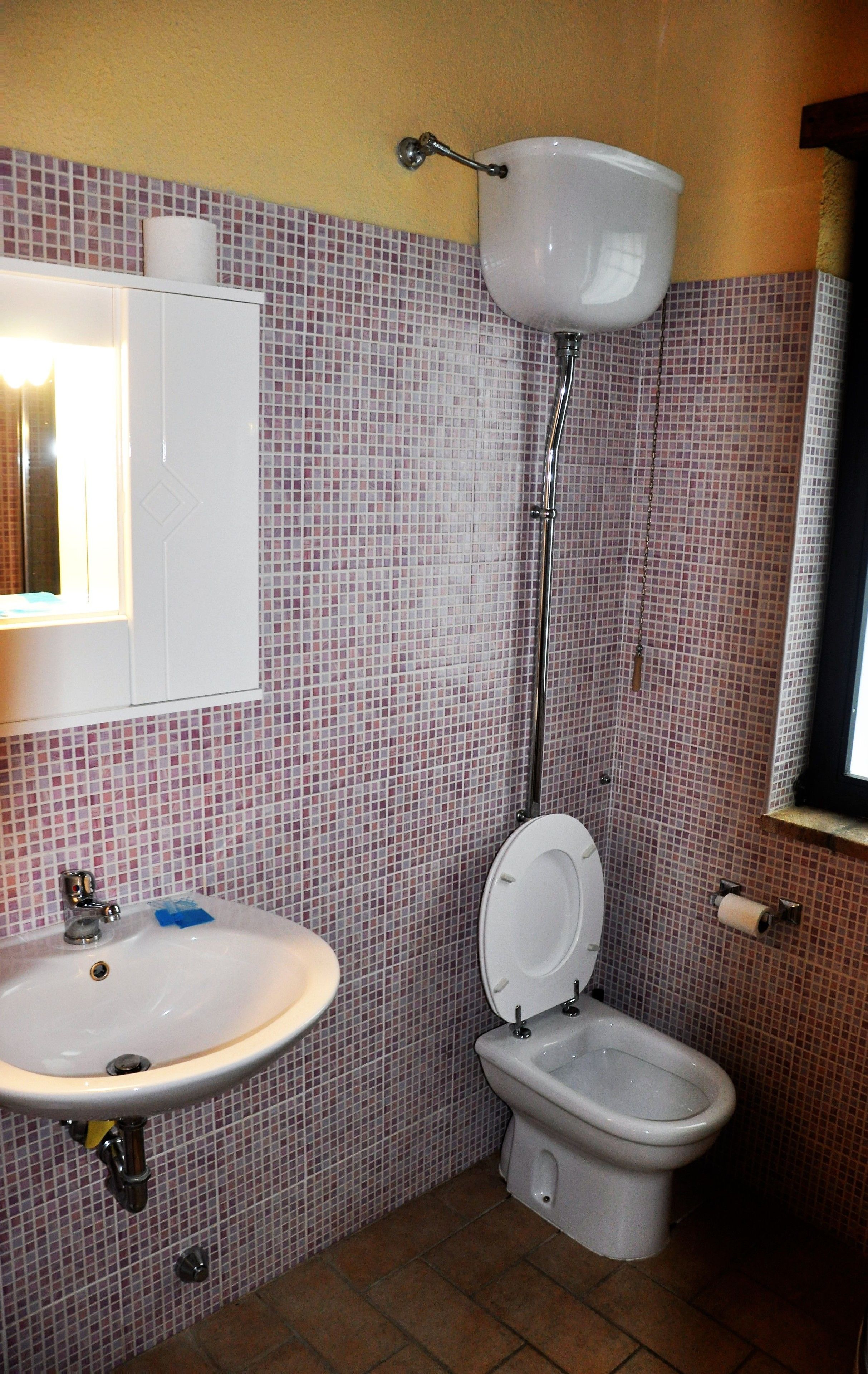 Ein Badezimmer mit Toilette, Waschbecken und Spiegel.