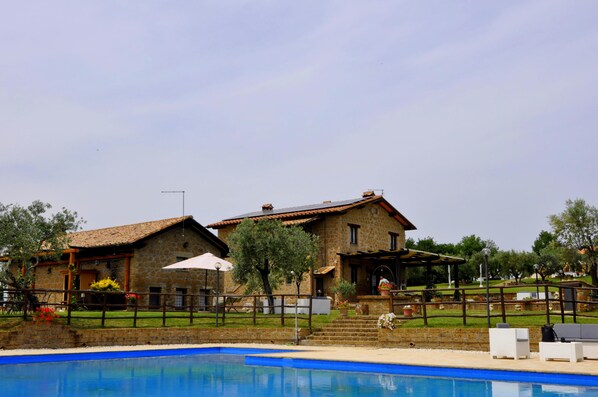 A stone house with a pool, outdoor furniture, and a pergola. - Borgo Nociquerceto (Tarano)