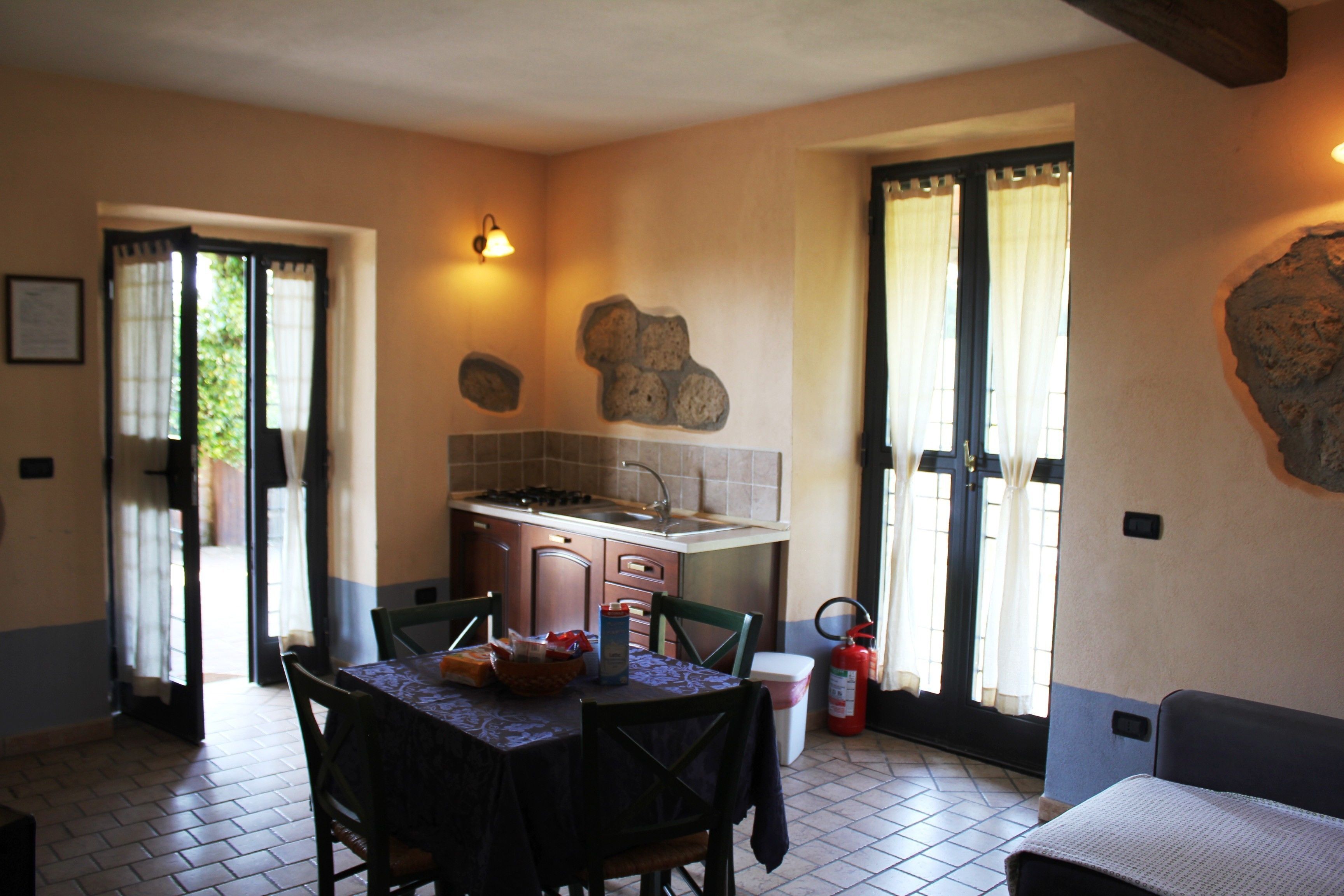 A compact kitchen with a dining area, a sink, and a fire extinguisher.