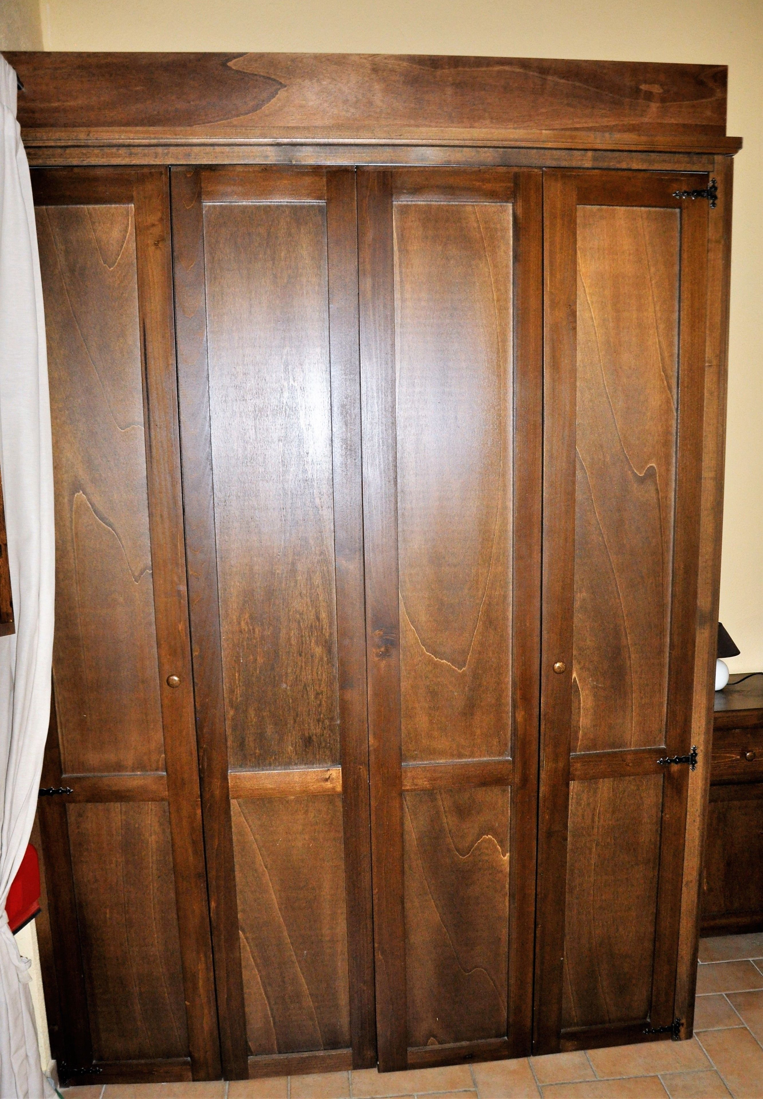 Un armario de madera con varias puertas y un tirador.