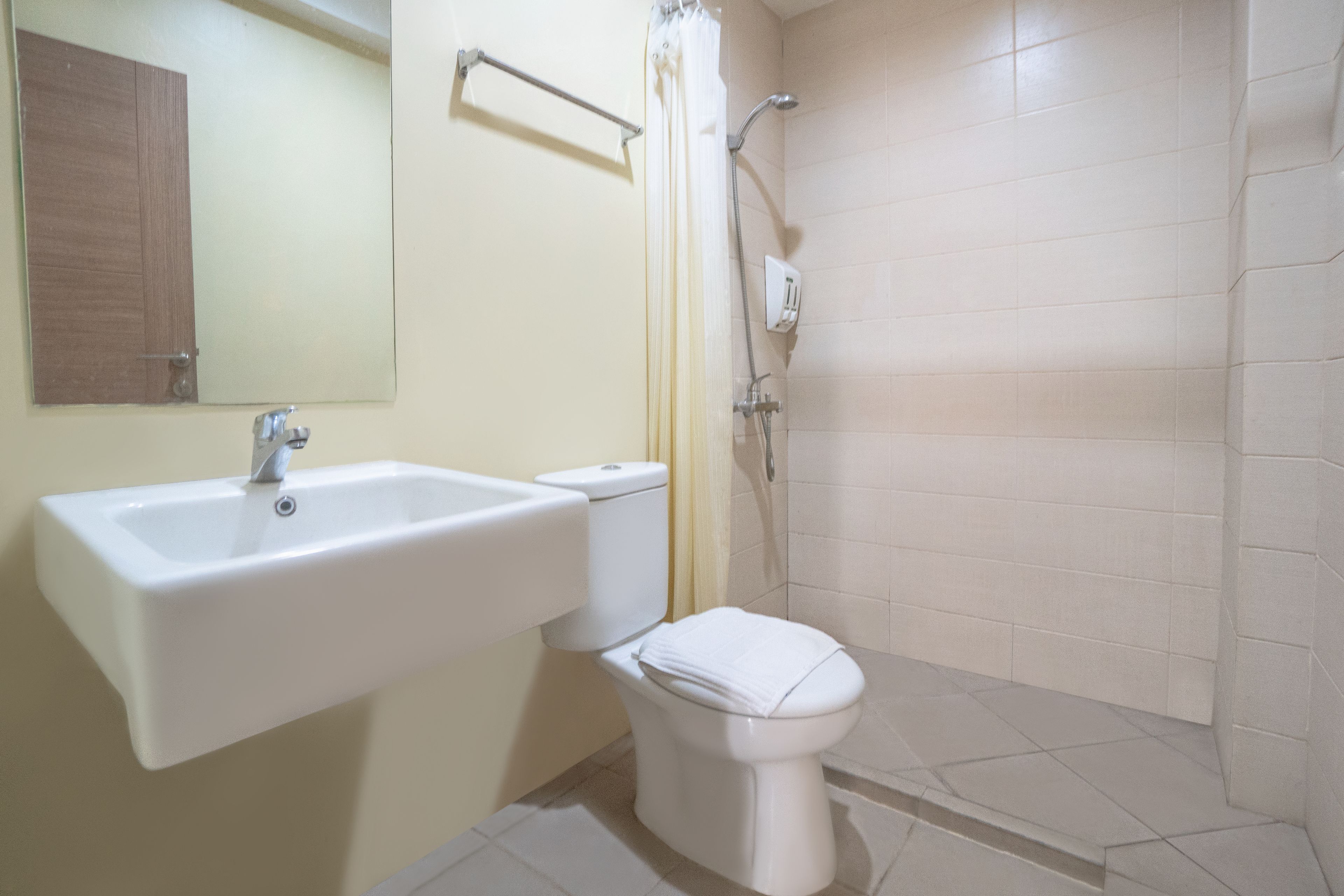 A bathroom with a white sink, toilet, and shower.
