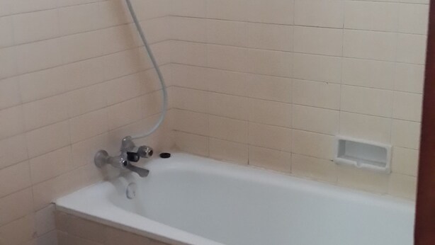 Un baño con bañera, inodoro y ducha.