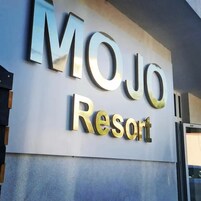 Skiltning for MOJO Resort med store, metalliske bogstaver.