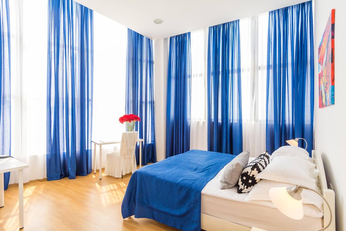 Un dormitorio con cama, escritorio y silla.