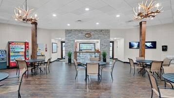 A spacious indoor area with a reception desk, seating arrangements, and a vending machine.