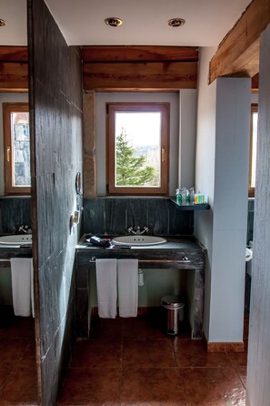 A bathroom with two sinks, a window, and a view of greenery outside. - Enclave Soria (Cidones)