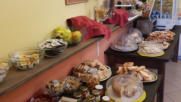 Una mesa de buffet con diversos alimentos, como frutas, pastelería y salsas.