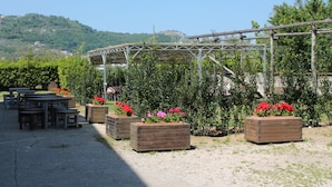 Un área ajardinada con jardineras de madera y una estructura de pérgola.