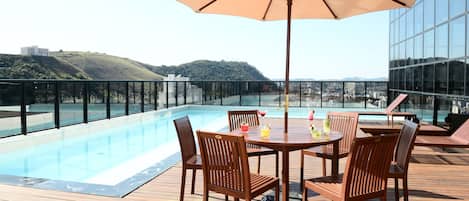 Een buitenzwembad en ligstoelen