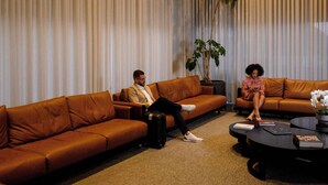 A modern living room with brown leather sofas, a coffee table, and a large potted plant. - Trade Hotel (Juiz de Fora)