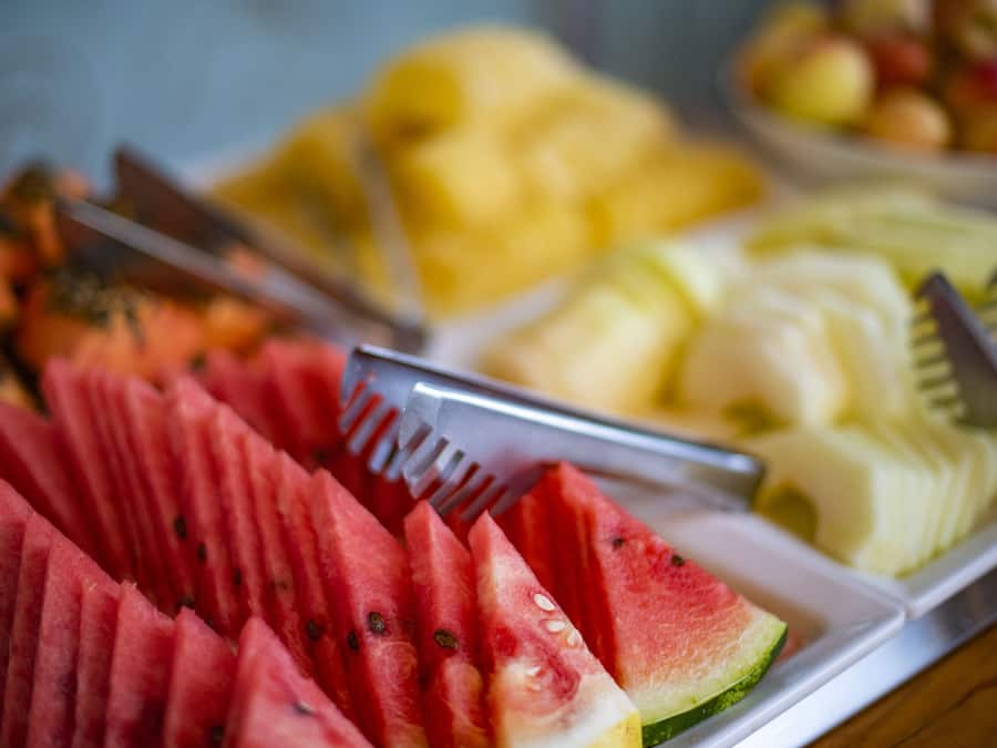 Uma travessa de frutas com melancia, melão e outras frutas.