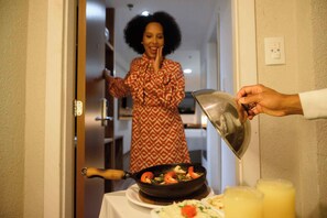 A person pouring sauce into a pan on a table. - Trade Hotel (Juiz de Fora)