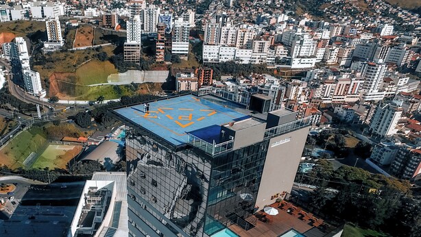 A high-rise building with a rooftop pool and a glass facade. - Trade Hotel (Juiz de Fora)