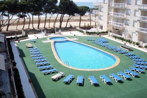 A pool area with blue lounge chairs and a small pool. - Cala Montero 3000-cala Gonzalez (Alcala de Xivert)
