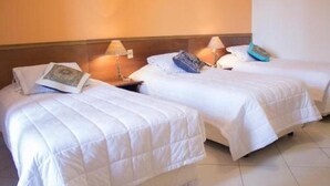 A hotel room with two single beds, each with a white duvet and pillows, and bedside lamps. - Asuncion House (Asunción)