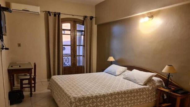 A hotel room with a bed, a desk, and a chair. - Asuncion House (Asunción)