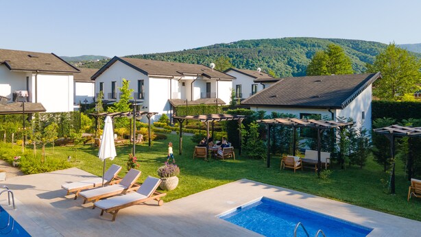 Un quartier résidentiel doté d’une piscine, de chaises longues et d’un jardin.