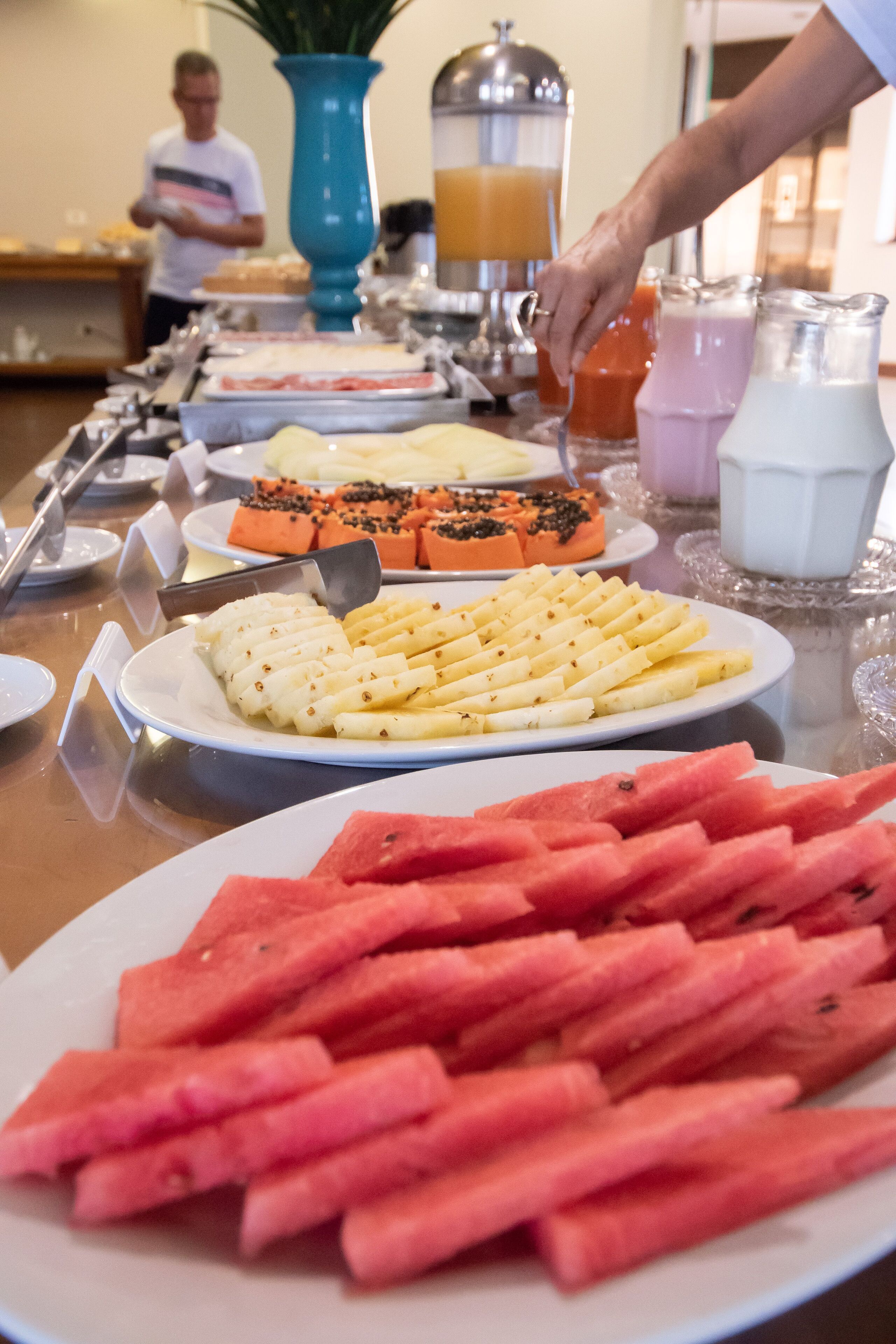 Un bufé con diferentes opciones de comida, incluyendo rebanadas de sandía, queso y otros platos.